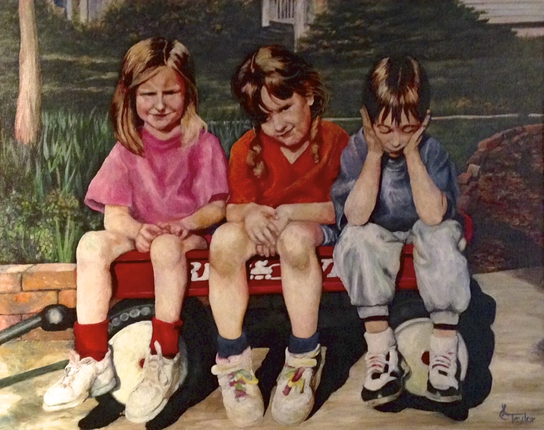 Three children sitting on a red wagon