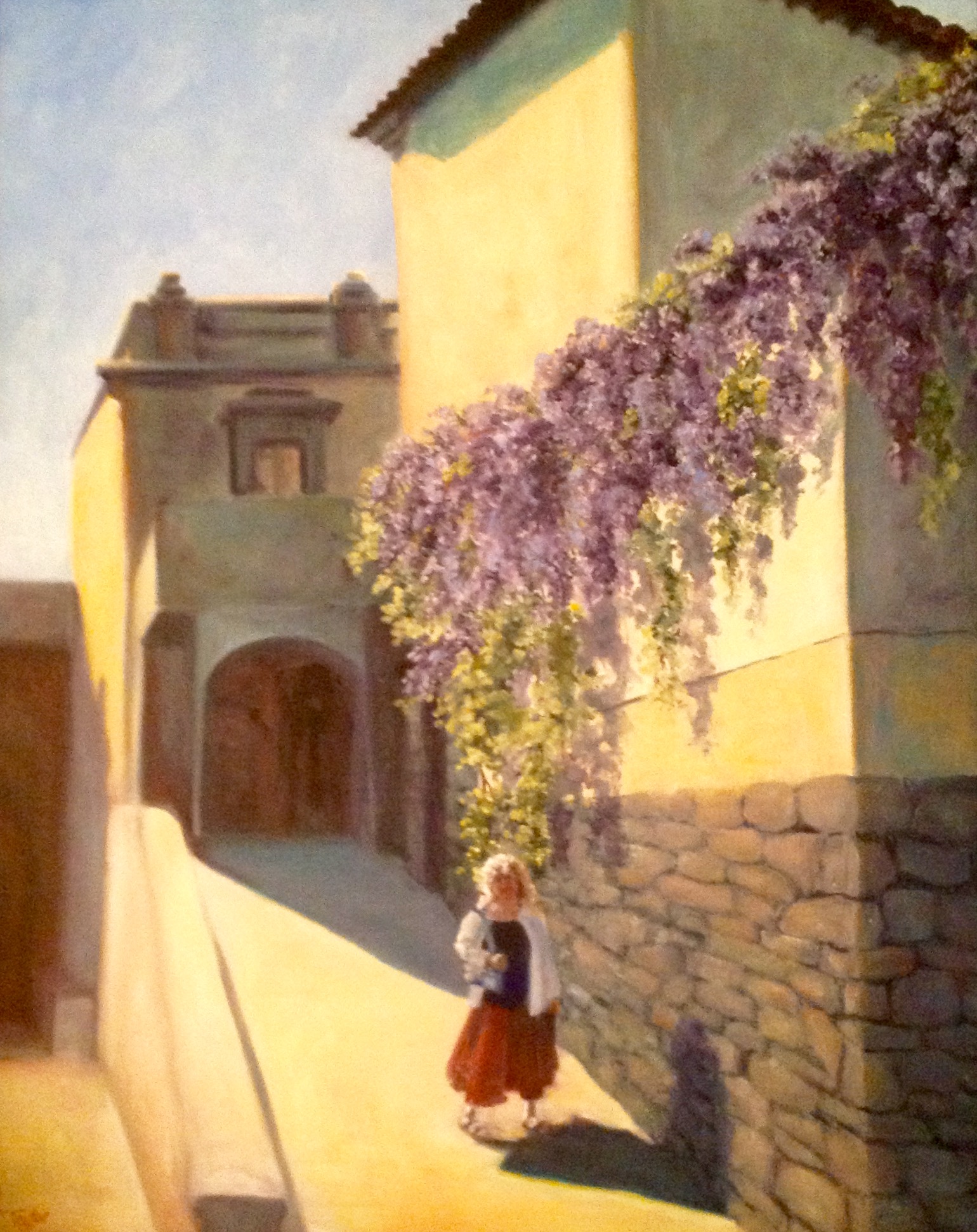Woman in red skirt walking on sunlit street with purple wisteria