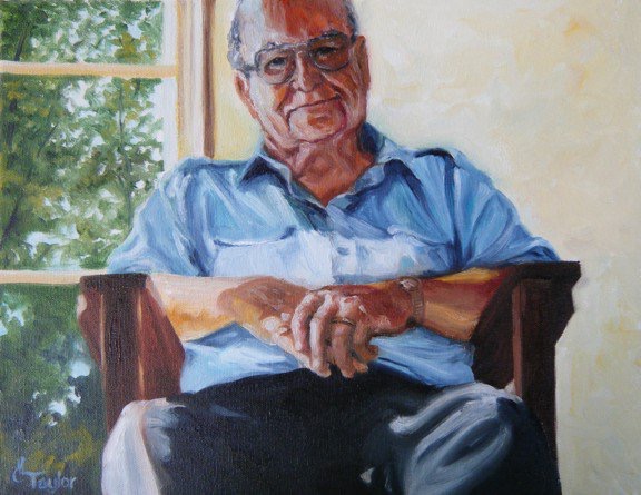 Elderly man in blue shirt sitting in chair