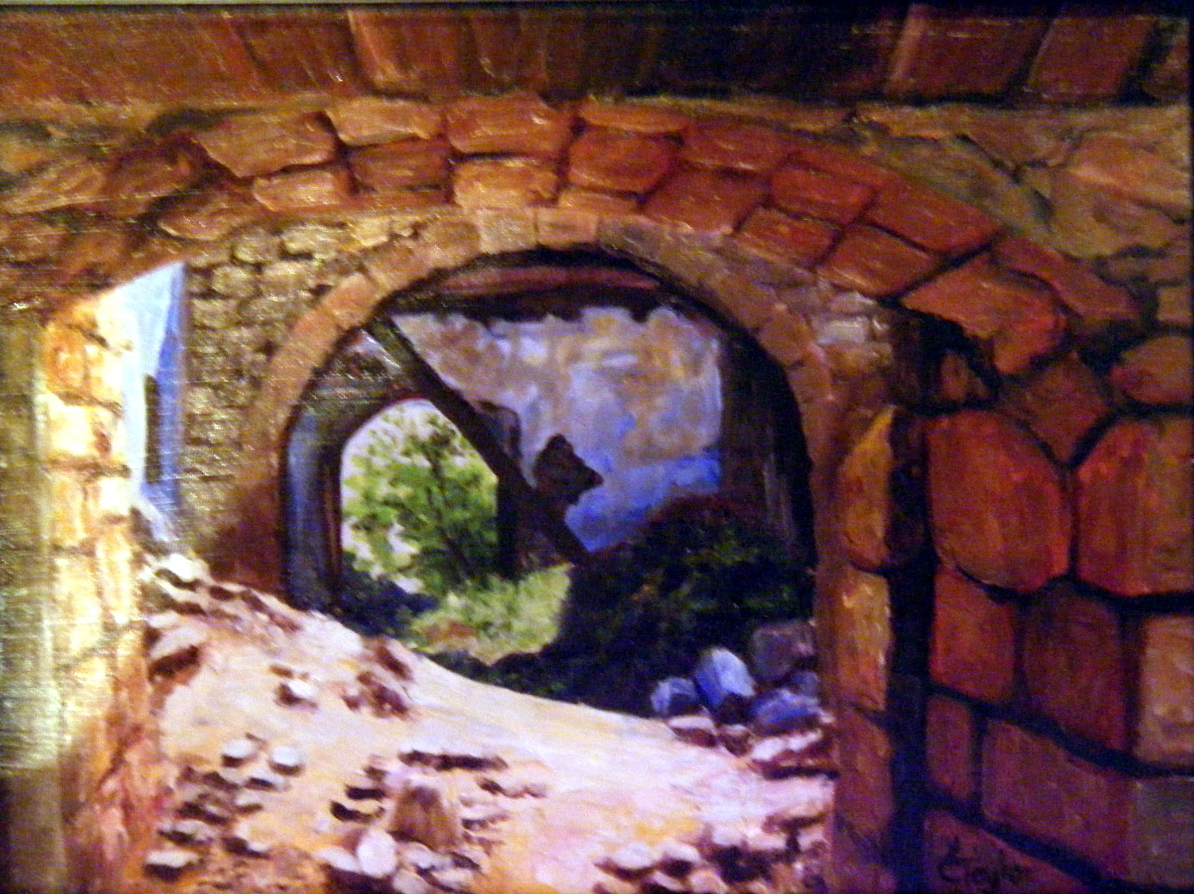 Stone archway of castle ruins with view of greenery beyond